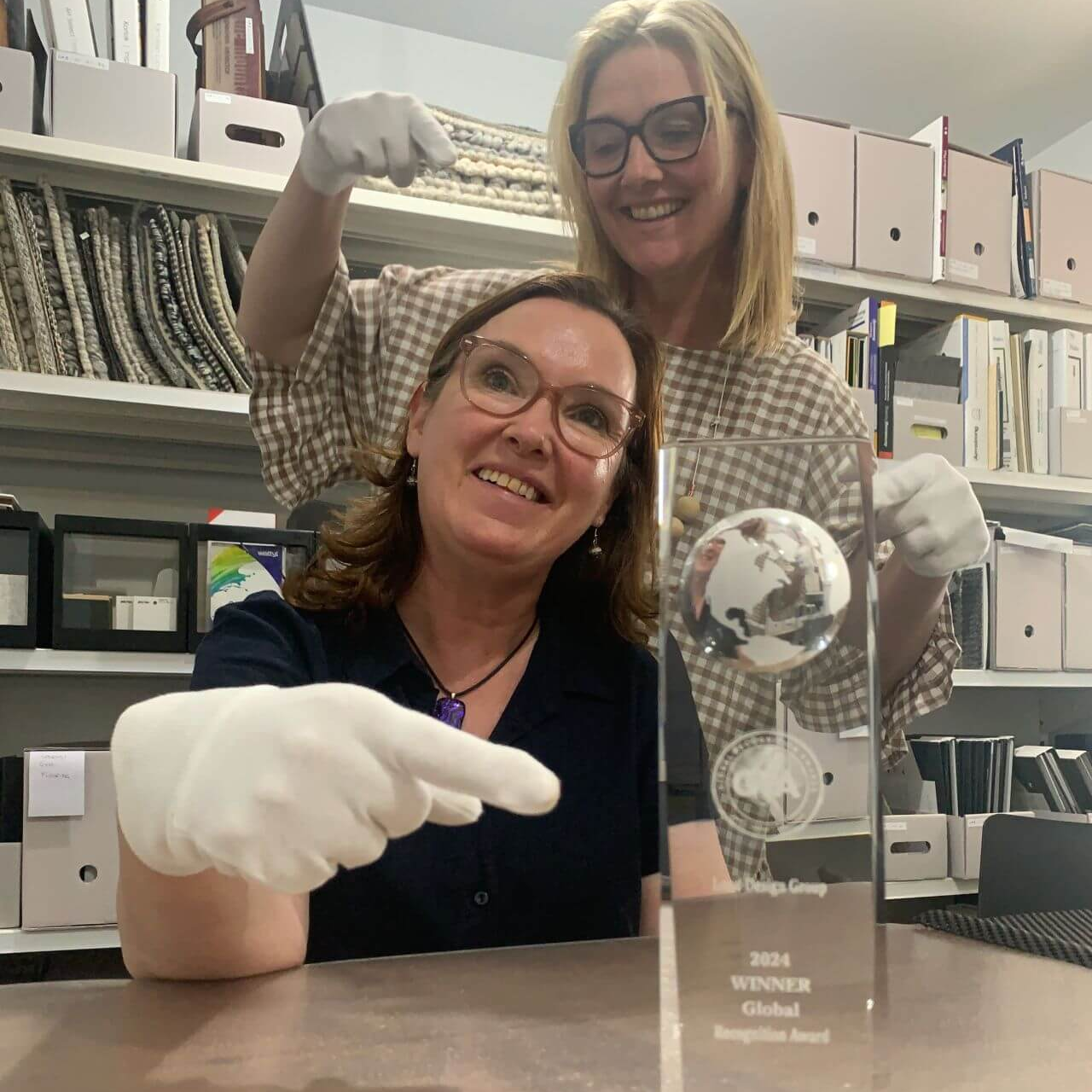 Photograph of Angela Dobson-Block and Lousie Dobson Trease showing off their trophy for the Global Recognition Awards